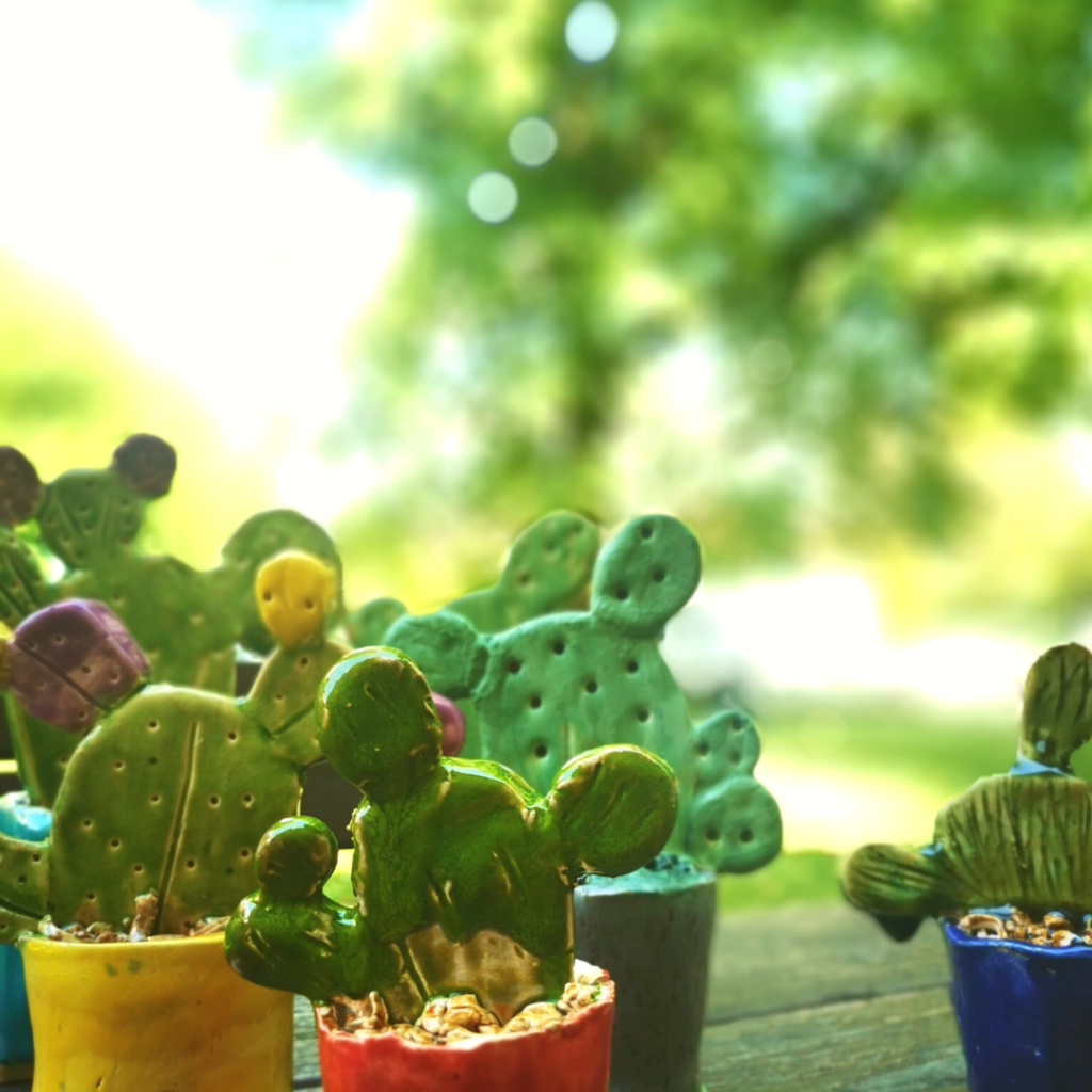Zdjęcie przedstawione zielone kaktusy wykonane z ceramiki